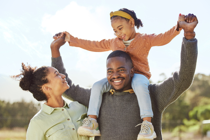 Family of 3 in Walker smiling about their rewards checking account with Essential Credit Union